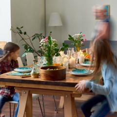 An image of the family dining table with a blurred moving vision of two children and two adults around it 